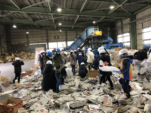古紙の中からリサイクルできないビニールなどを取り除く作業を体験する児童ら