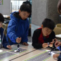 ペンライトを使ってソーラーミニカーを走らせる子供たち（市生涯学習フェスティバル「まなトピア」）