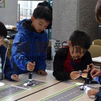 ペンライトを使ってソーラーミニカーを走らせる子供たち（市生涯学習フェスティバル「まなトピア」）