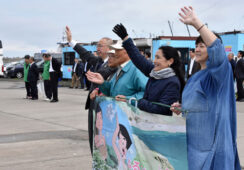 港で手を振る「ビザなしサポーターズたんぽぽ」─トレードマークのジョバンニの島の応援旗は日本語、ロシア語があり使い分けている