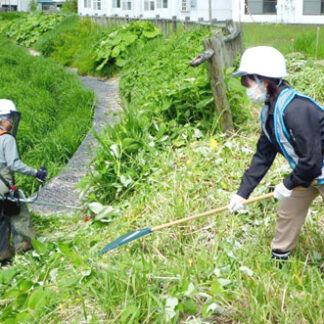 辻谷建設が湯川排水路で草刈り　景観保全や機能保守(2022-06-17)